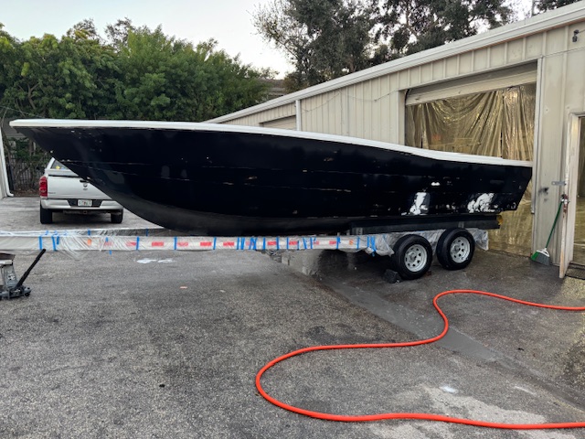 Freshly painted black boat hull outside the Harper Marine Services shop in Clearwater